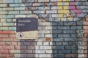 An accessible entry sign on a colourful wall