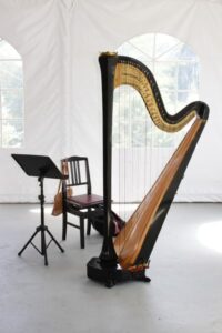 A large harp instrument in white marquee tent