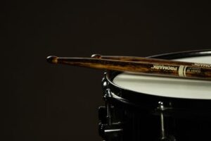 A close up view of a drum and two drumsticks