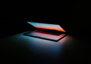 A closing laptop in a dark room used for digital learning