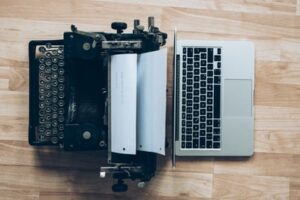 Digital learning methods vs traditional learning methods symbolised with a laptop and a typewriter