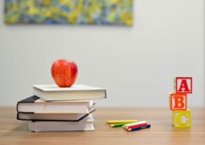 A series of books, an apple and building blocks in a classroom