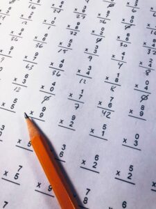 A pencil resting on top of a child's maths quiz