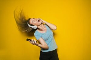 A lady listening to music on her headphones and dancing