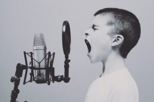 A young boy singing into a micriphone