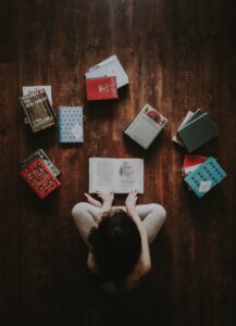 A child with many books in front of them on the floor