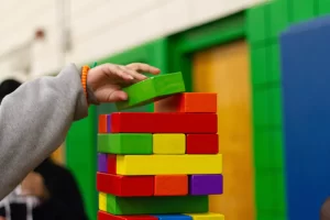 A child playing with a stack of colourful blocks