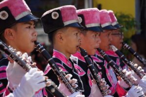 A band standing in a row playing the clarinet