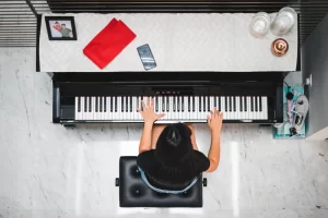 An aerial view of a child learning to play the piano