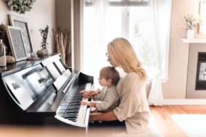 A mother teaching a child how to play the piano