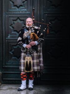 A Scottish man playing the bagpipes