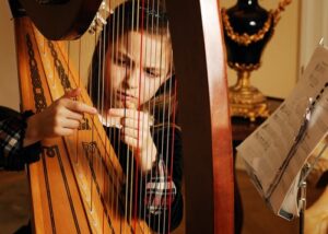 A young girl playing the harp