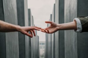 Two hands outstretched in the middle of the holocaust memorial in Berlin