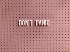 Don't panic pinned to a pink wall