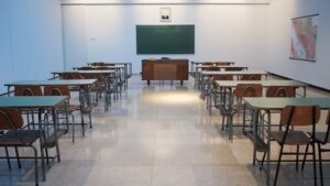 An empty classroom with rows of desks