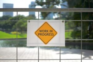 A work in progress sign on a city fence